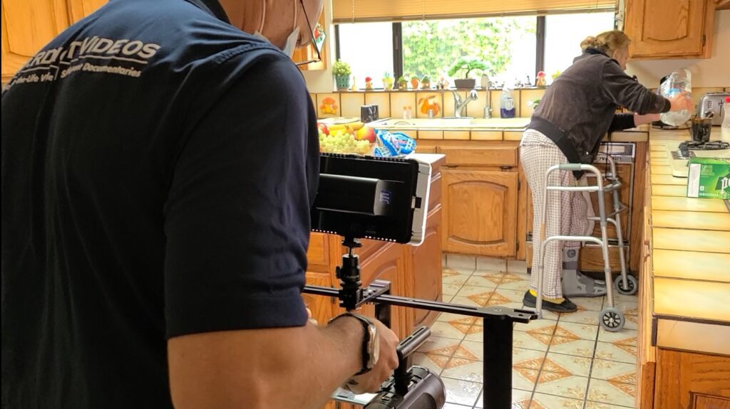 Image of man filming woman in kitchen