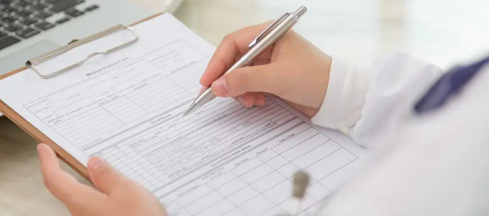 a doctor filling out a medical history form